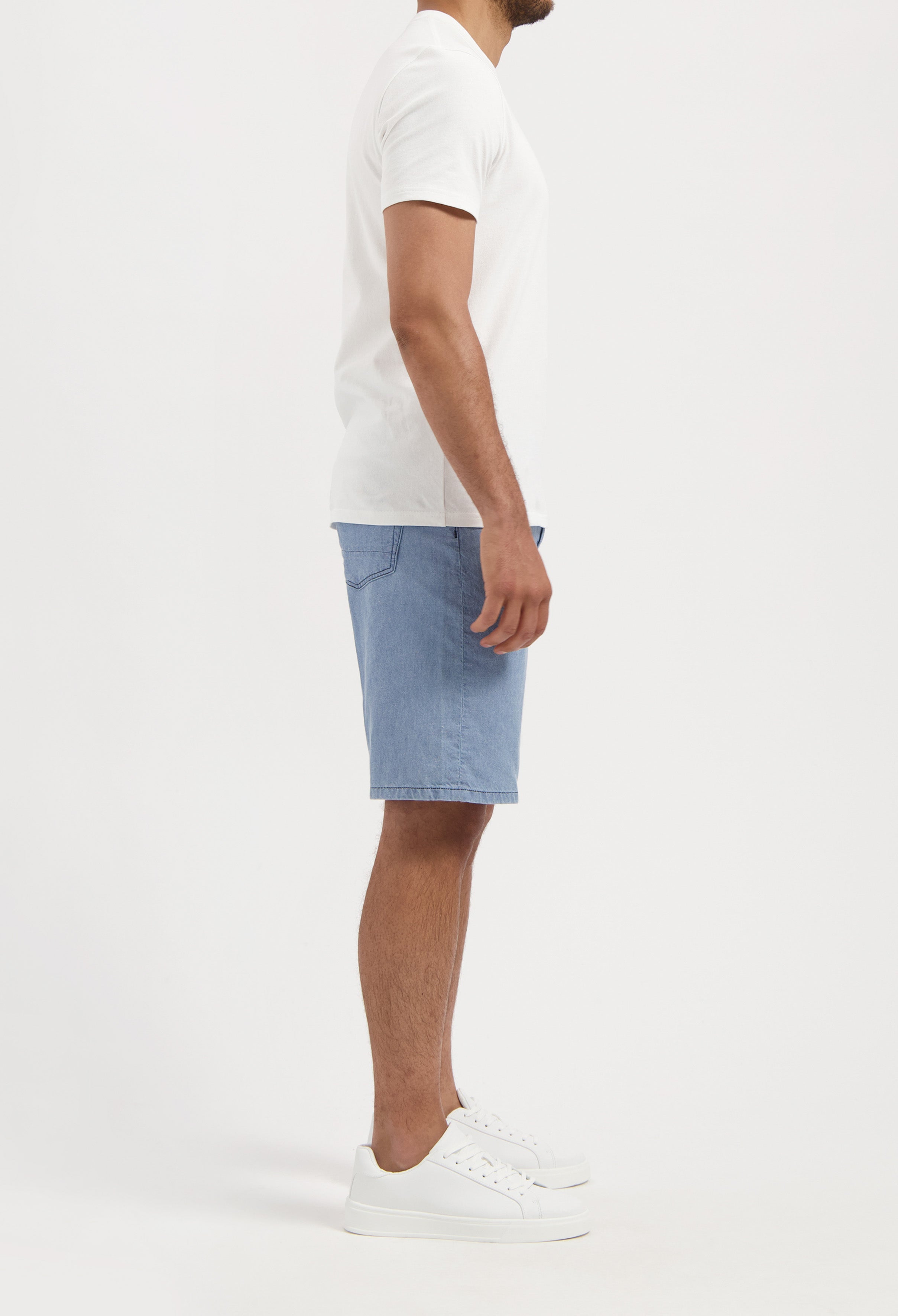 Sustainable MUD Jeans in deep blue denim, crafted from organic cotton, paired with a light gray sweater for an eco-friendly look.