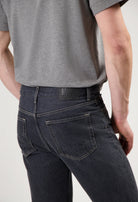 Sustainable black MUD Jeans crafted from organic cotton, paired with a cozy white sweater for ethical fashion style.