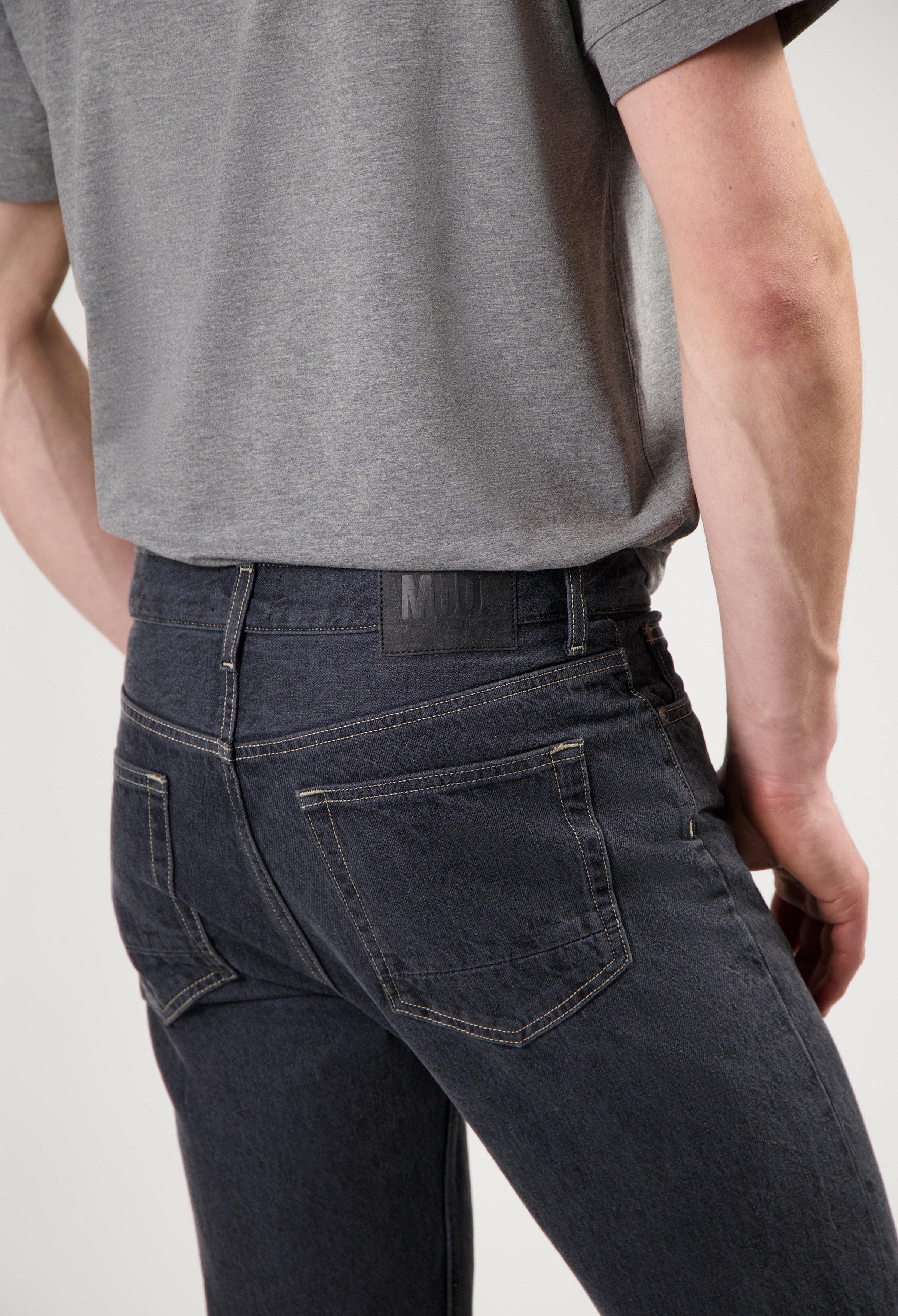 Sustainable black MUD Jeans crafted from organic cotton, paired with a cozy white sweater for ethical fashion style.