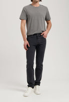 Sustainable MUD Jeans in black denim, paired with an ethical cream knit sweater, showcasing eco-friendly fashion.
