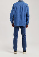 Sustainable MUD Jeans in dark denim, featuring a straight fit with ethical craftsmanship, paired with a white top.