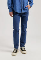 Sustainable MUD Jeans in dark blue denim, crafted ethically, paired with white shirt, showcasing classic fit style.
