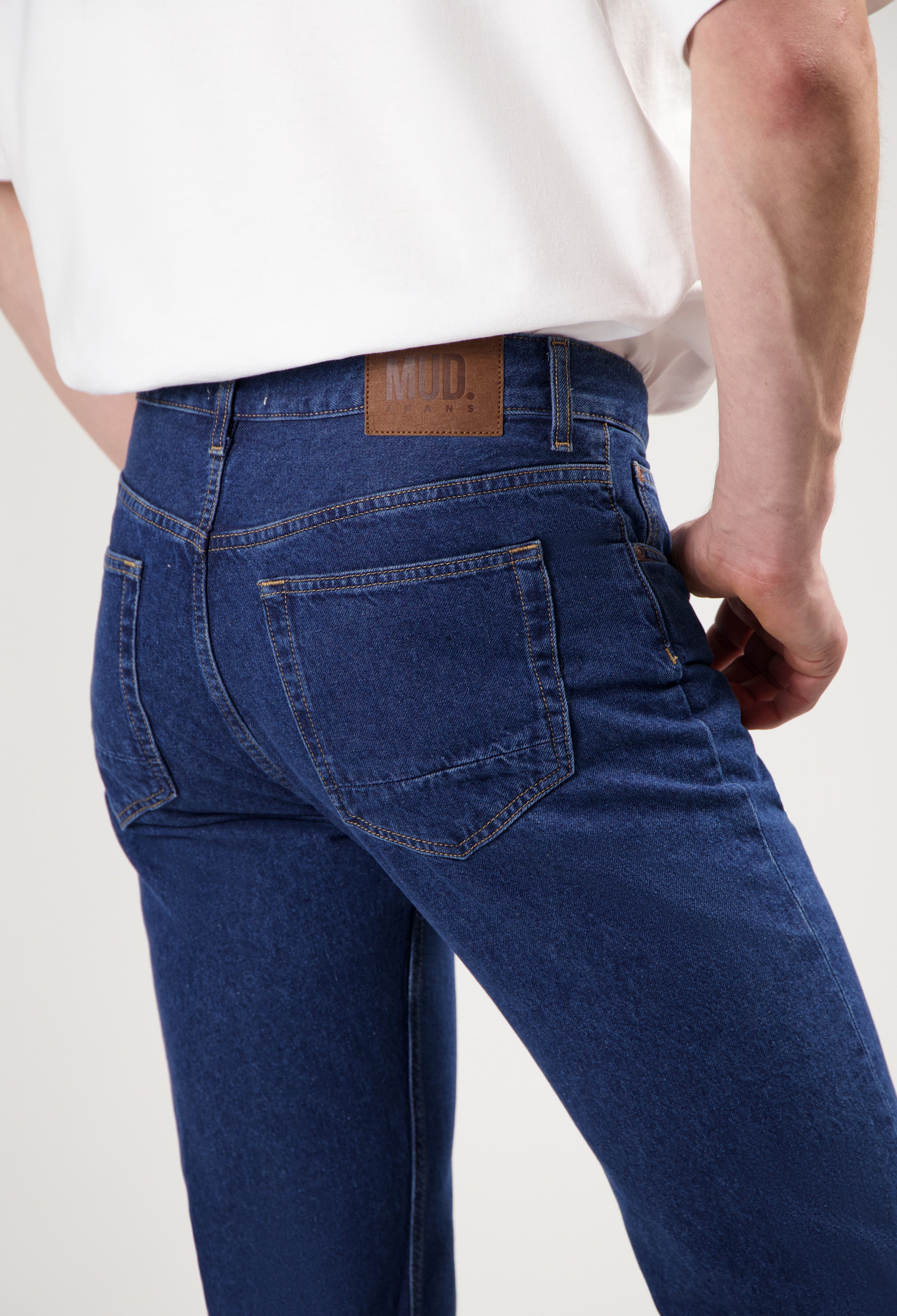 Sustainable MUD Jeans outfit in blue denim featuring an ethical shirt and classic fit jeans, paired with white sneakers.