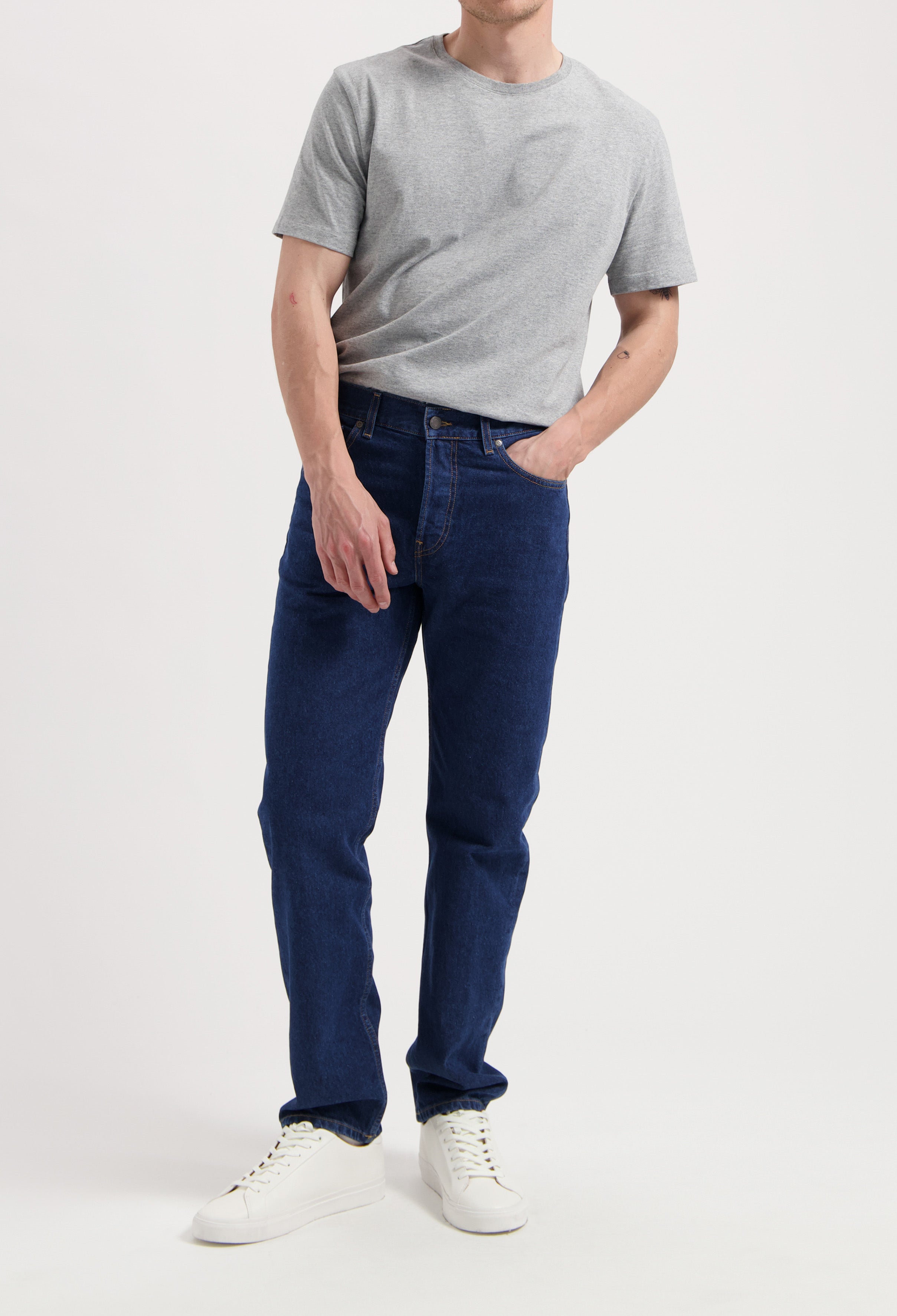 Sustainable MUD Jeans featuring a classic blue denim shirt and pants set, emphasizing ethical fashion with white sneakers.
