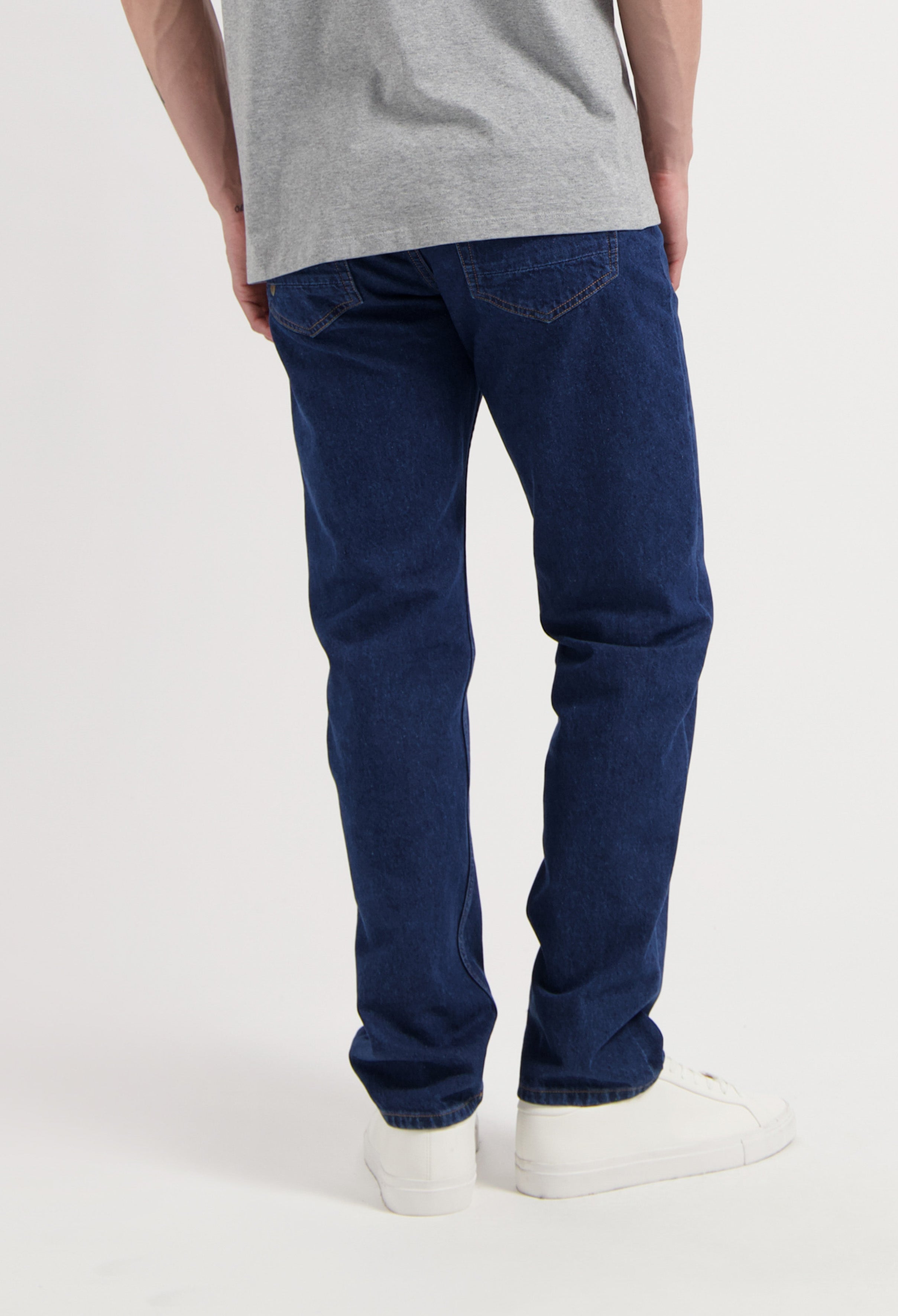 Sustainable MUD Jeans denim set in classic fit, featuring eco-friendly blue fabric and white sneakers.