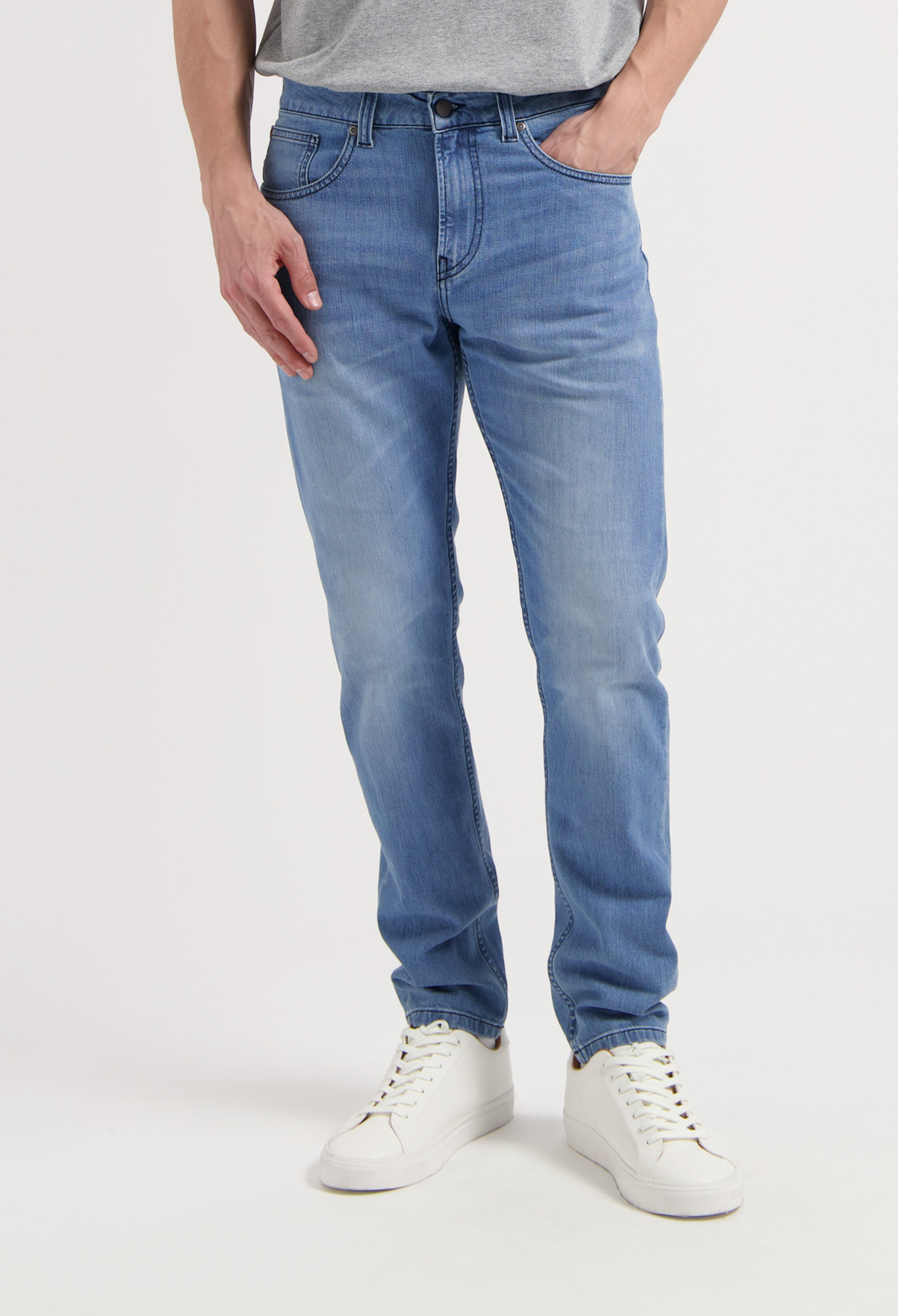 Sustainable MUD Jeans in dark blue denim with a relaxed fit, paired with a white tee and sneakers for an ethical look.
