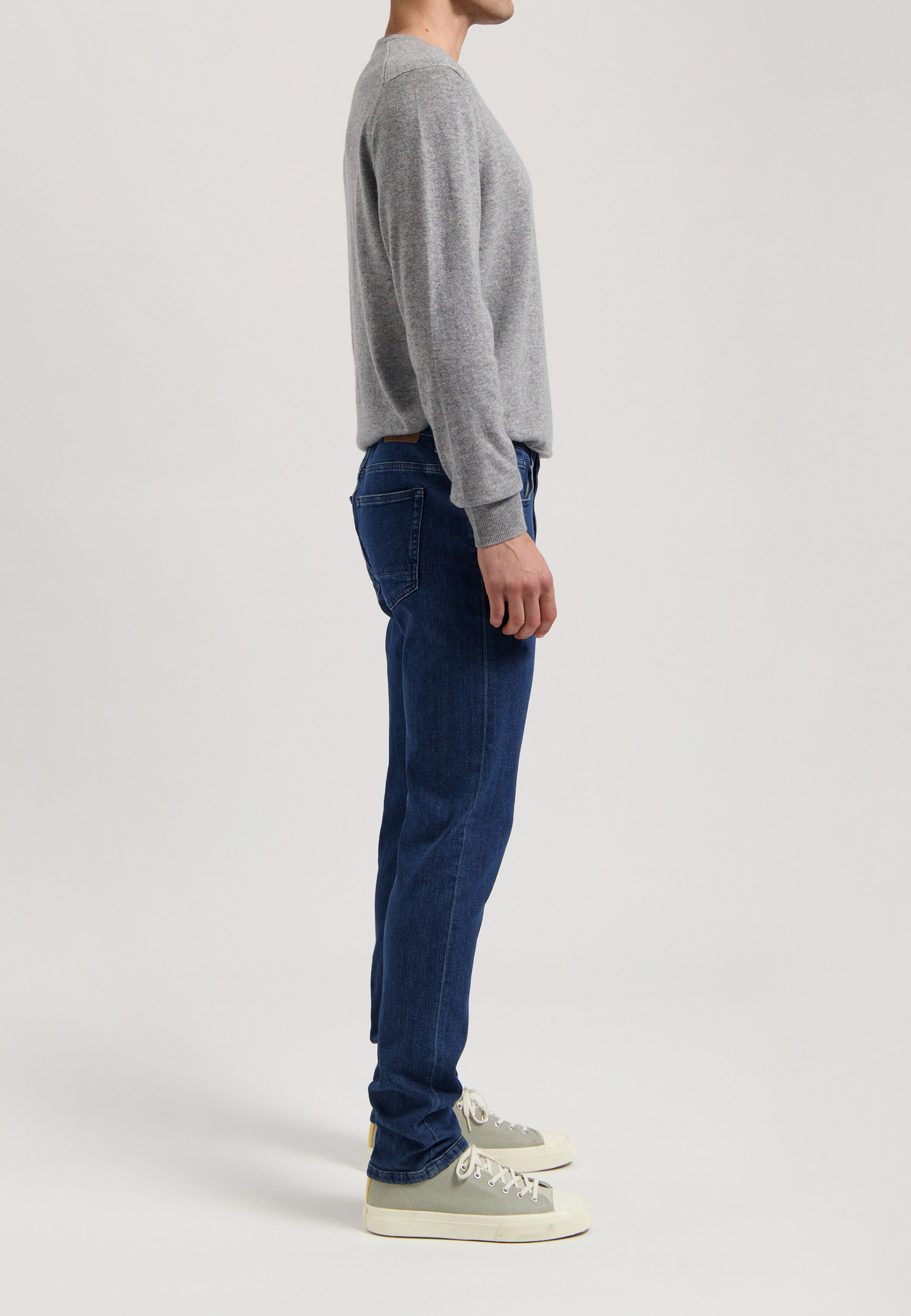 Sustainable MUD Jeans made from organic cotton in deep indigo, showcasing back pockets, emphasizing ethical fashion.