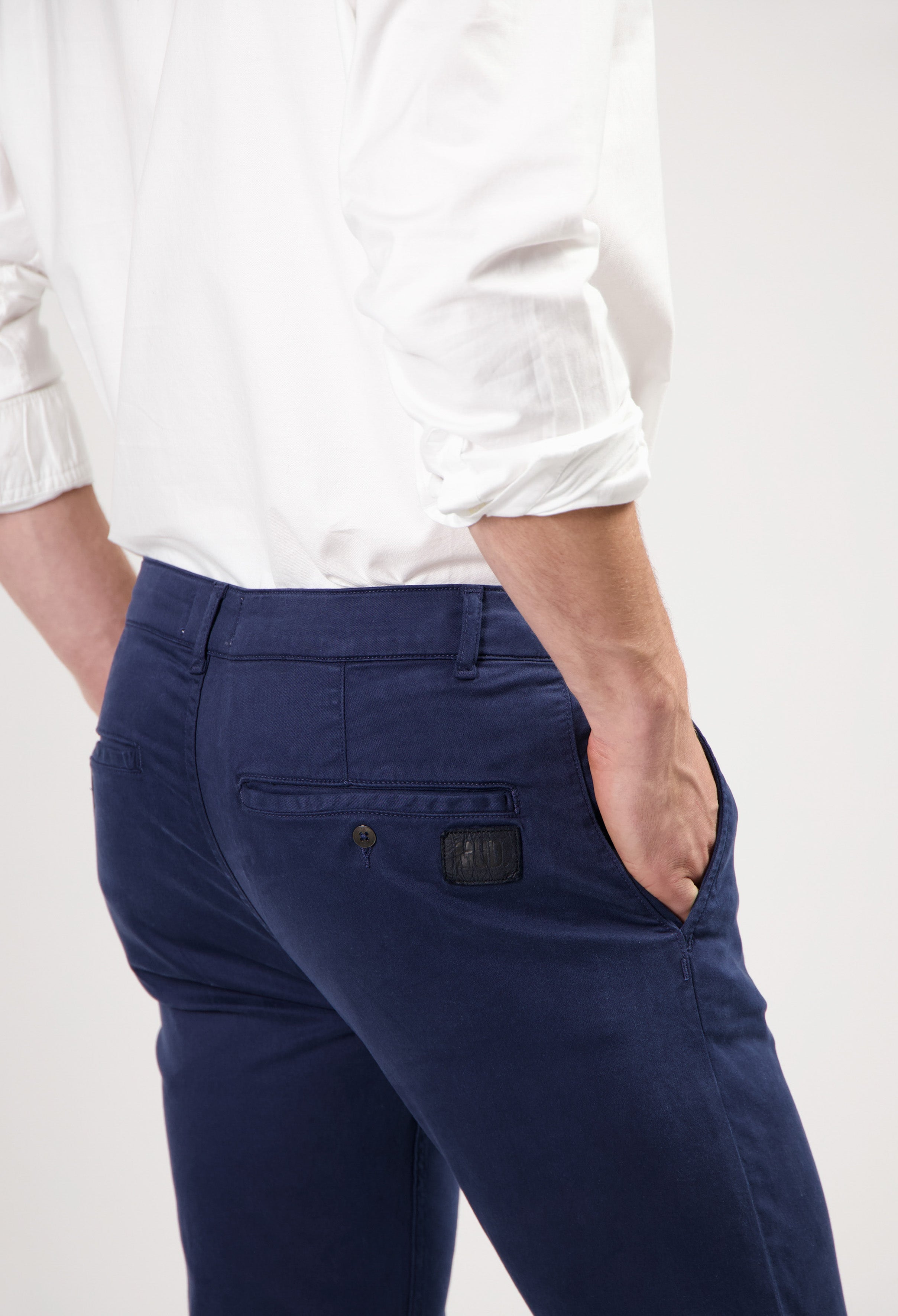 Sustainable MUD Jeans in dark gray denim, crafted ethically, showcasing a slim fit style paired with black sneakers.