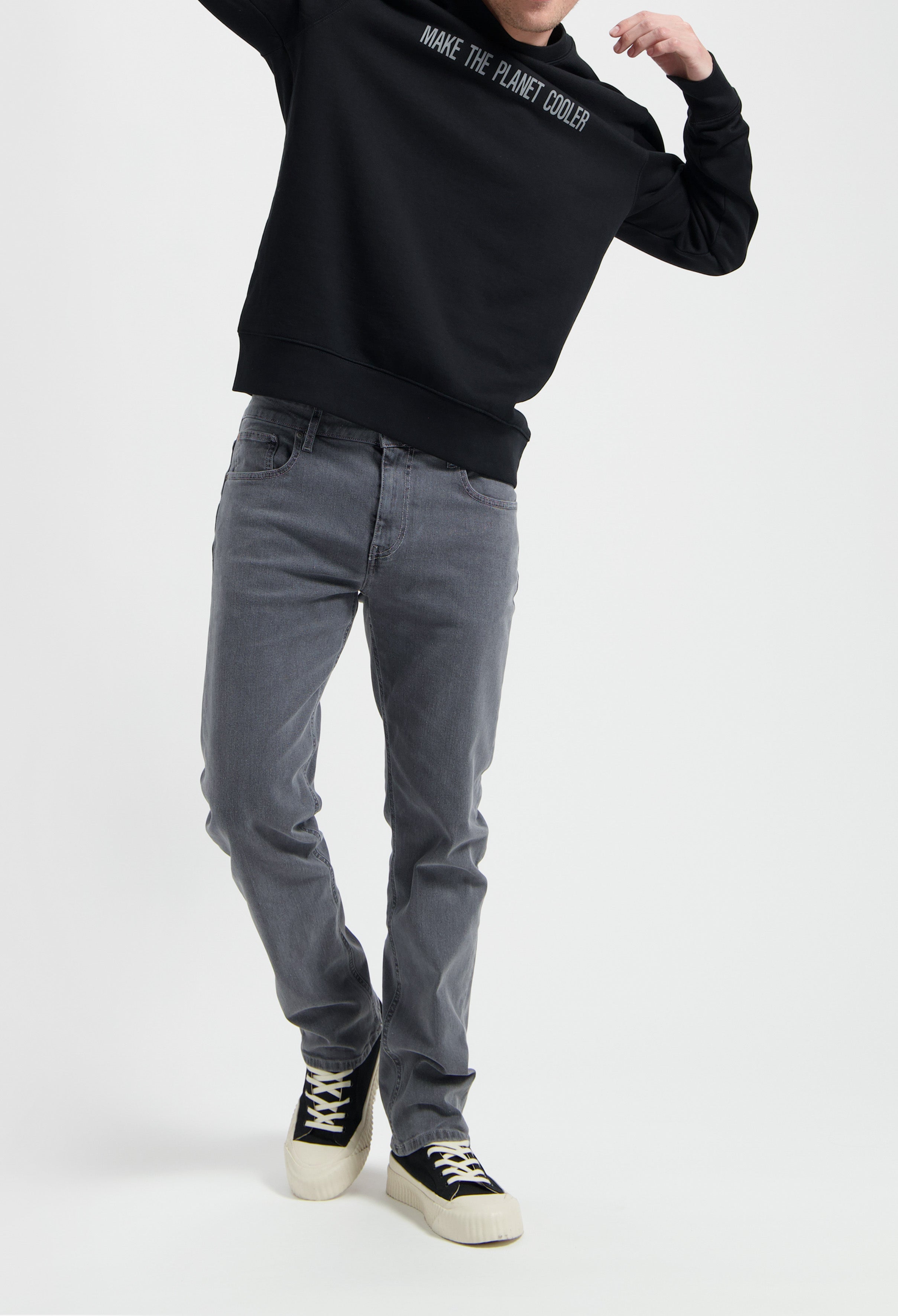 Sustainable MUD Jeans made from organic cotton in deep blue, shown with a gray sweater, embodying ethical fashion.
