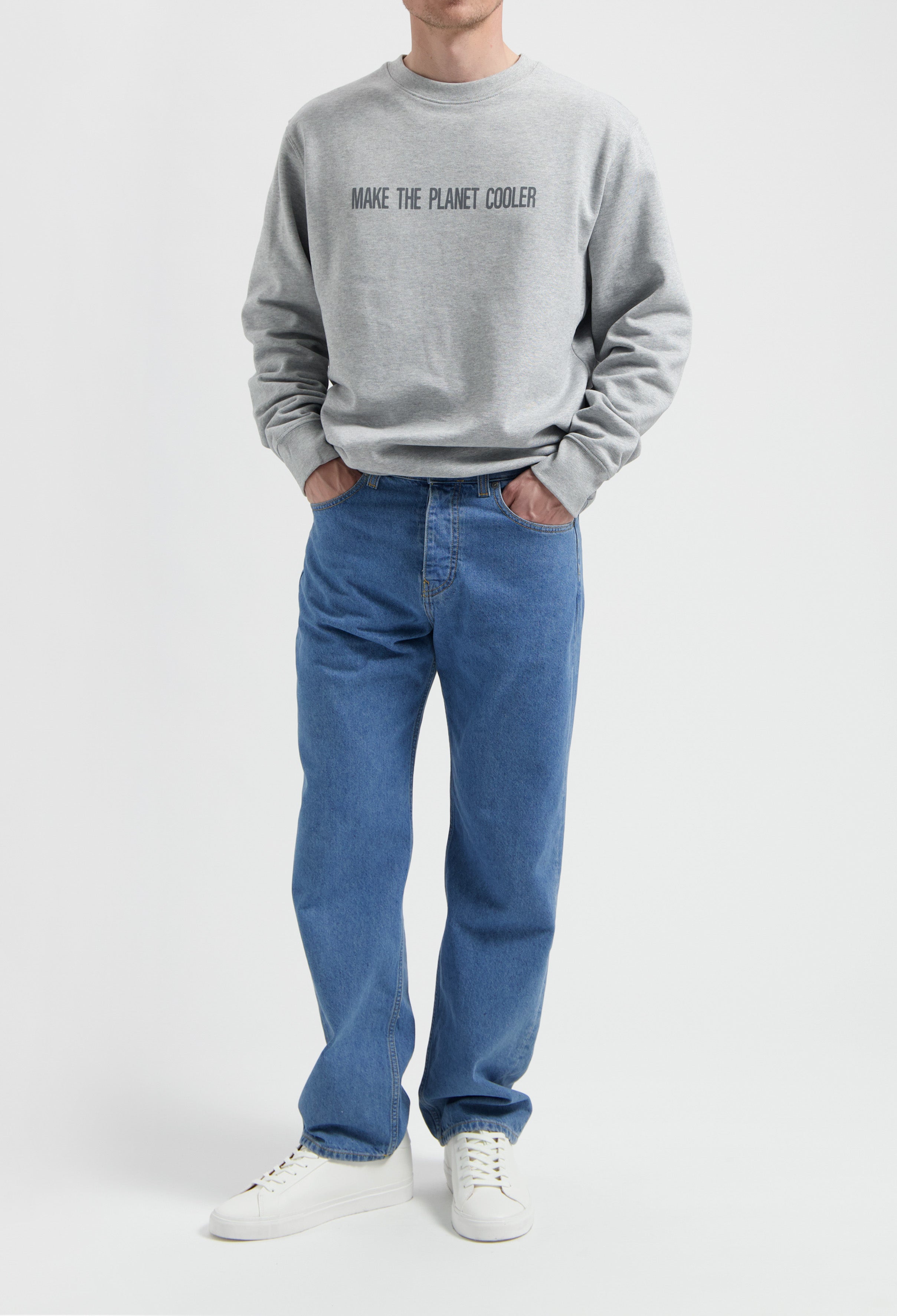 Sustainable MUD Jeans in classic blue denim, paired with a gray eco-friendly sweatshirt, embodying ethical fashion.