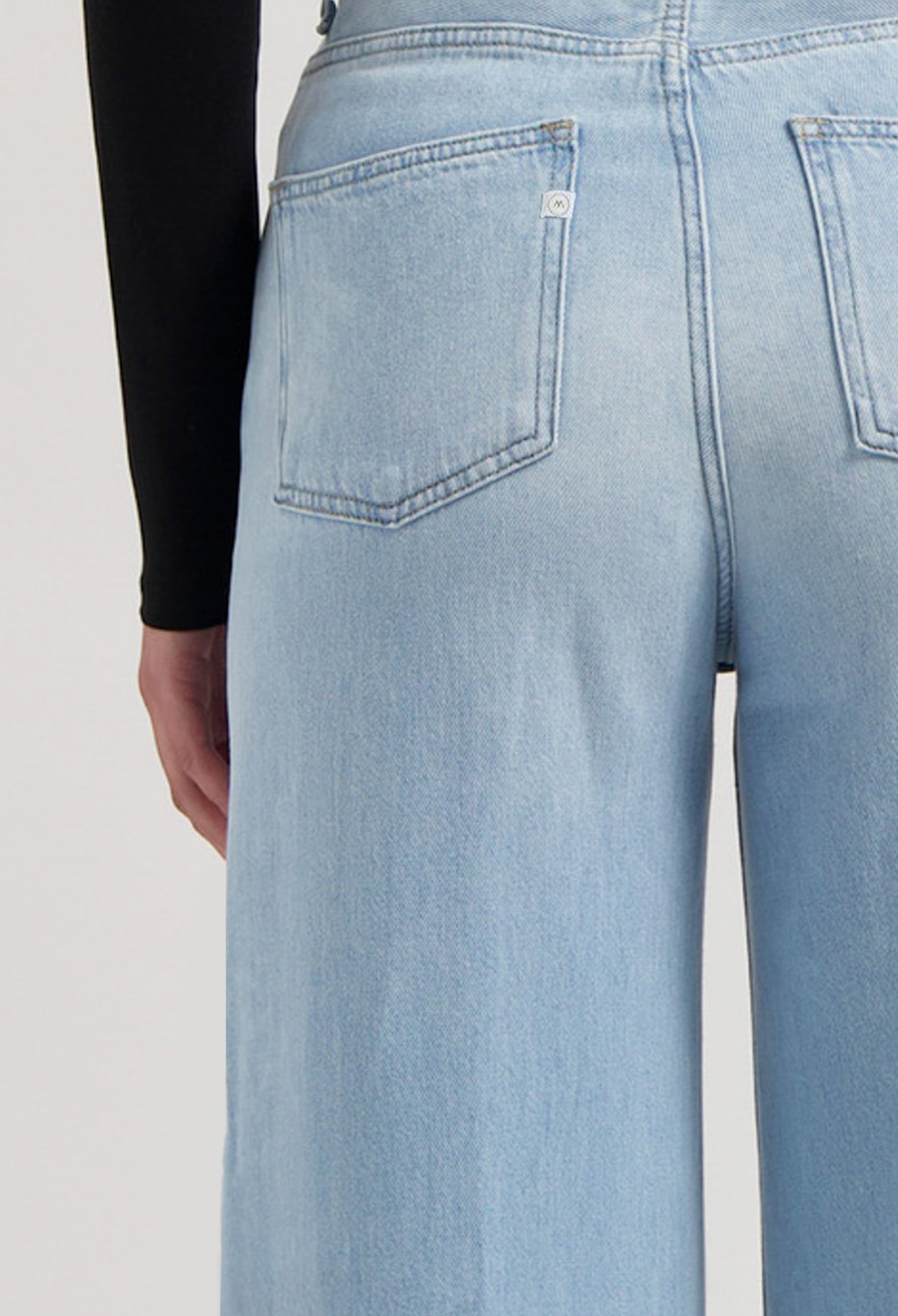 Light blue high-waisted denim jeans shown from the back, featuring wide-leg design and classic pocket stitching.