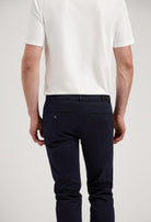 Sustainable MUD Jeans in white denim, crafted ethically from organic cotton, paired with a navy blue shirt.