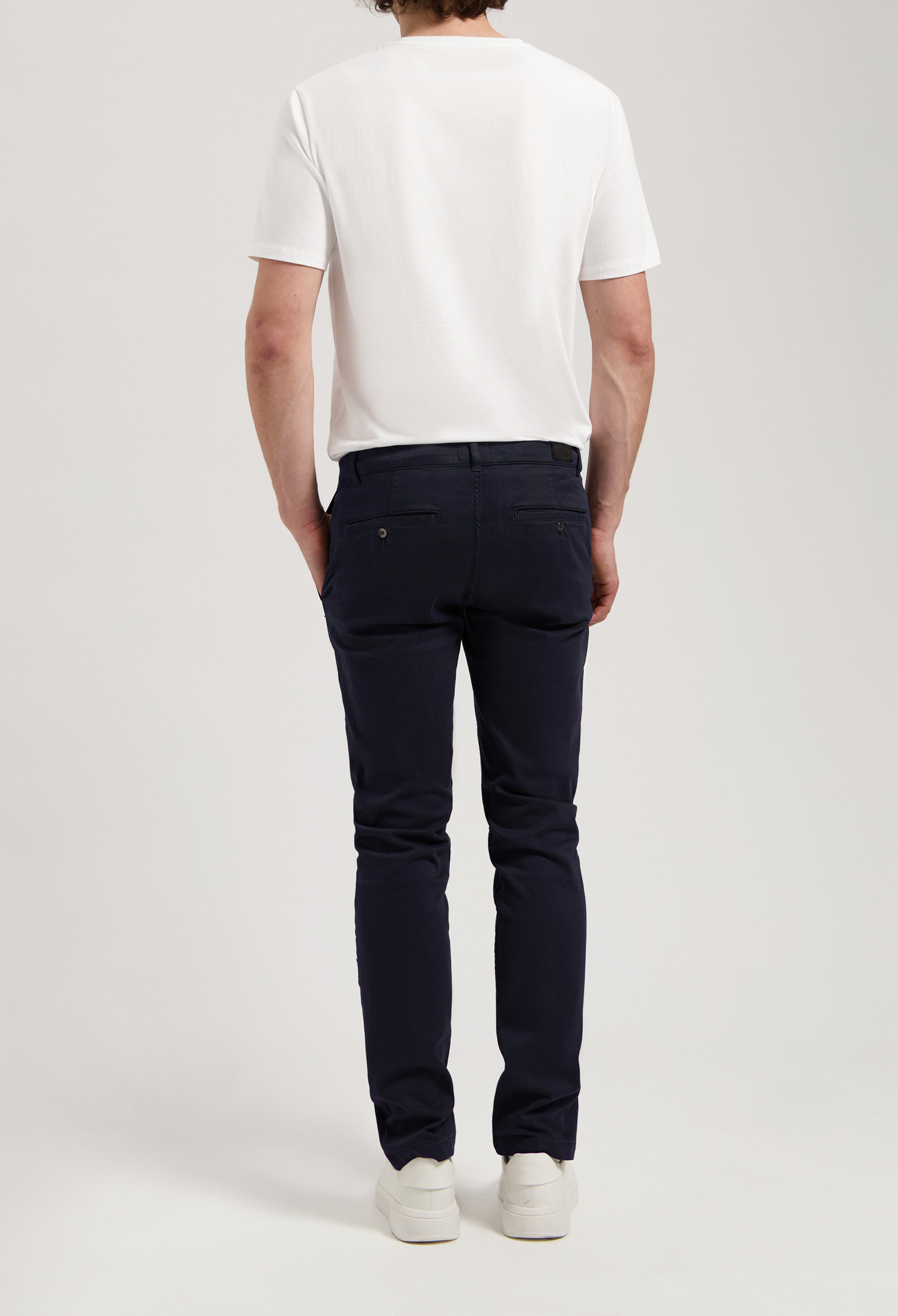 Sustainable MUD Jeans in white organic cotton, showcasing a straight fit, styled with a navy blue shirt.