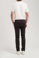 Sustainable MUD Jeans in dark gray denim, made from organic cotton, showcasing classic straight fit, worn with white top.