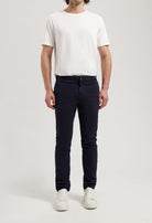 Sustainable MUD Jeans in off-white organic cotton, paired with a navy blue t-shirt, highlighting ethical fashion.