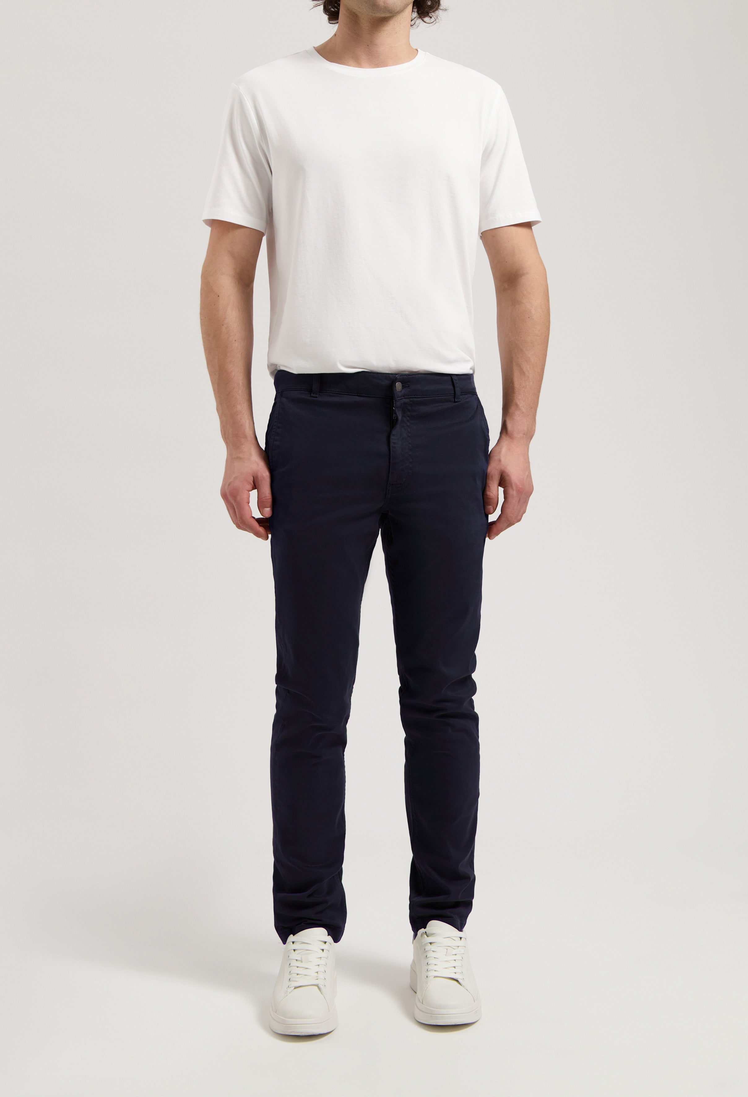 Sustainable MUD Jeans in off-white organic cotton, paired with a navy blue t-shirt, highlighting ethical fashion.