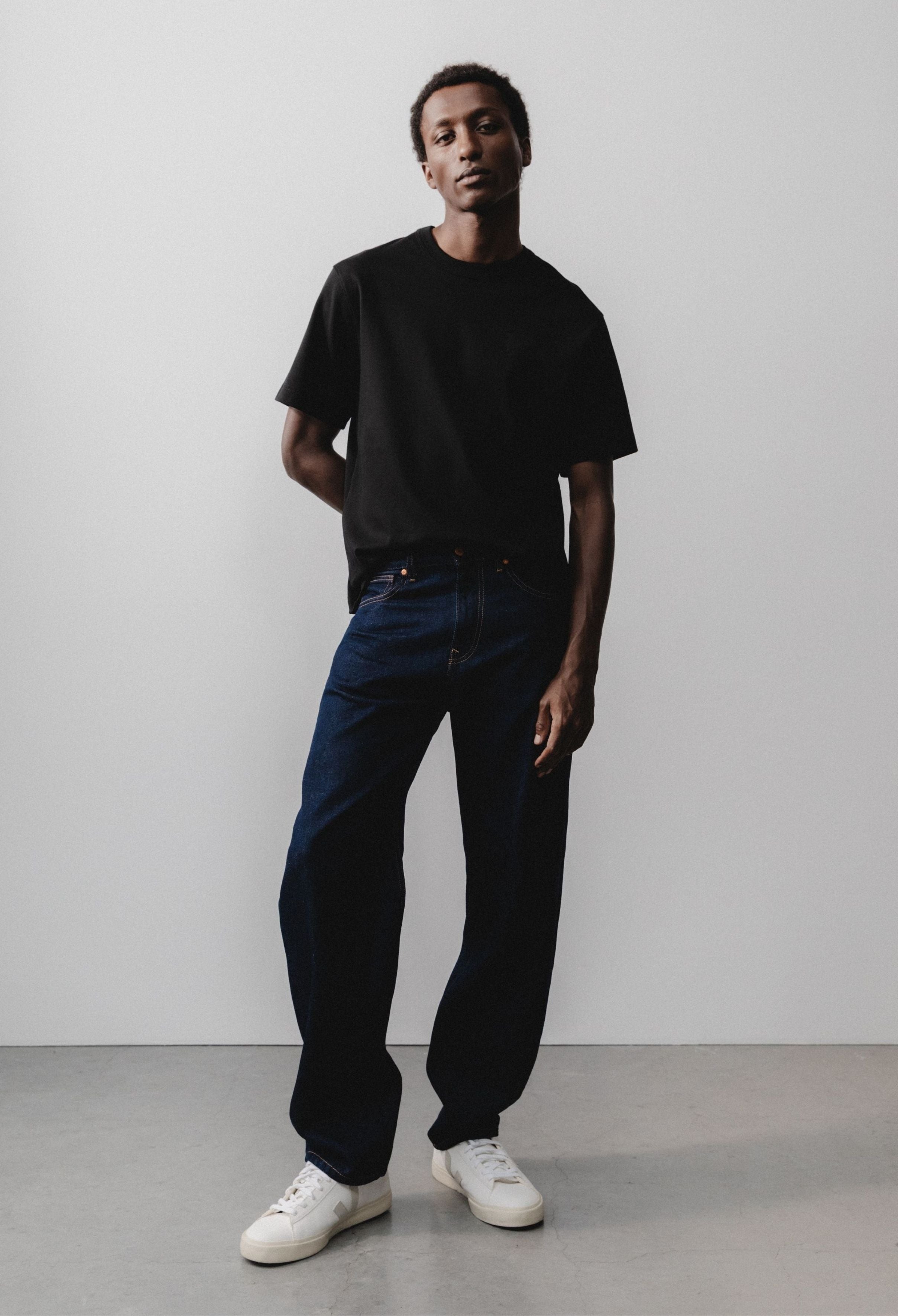 Sustainable MUD Jeans made of organic cotton in sleek black denim, paired with a gray sweater for an ethical style.