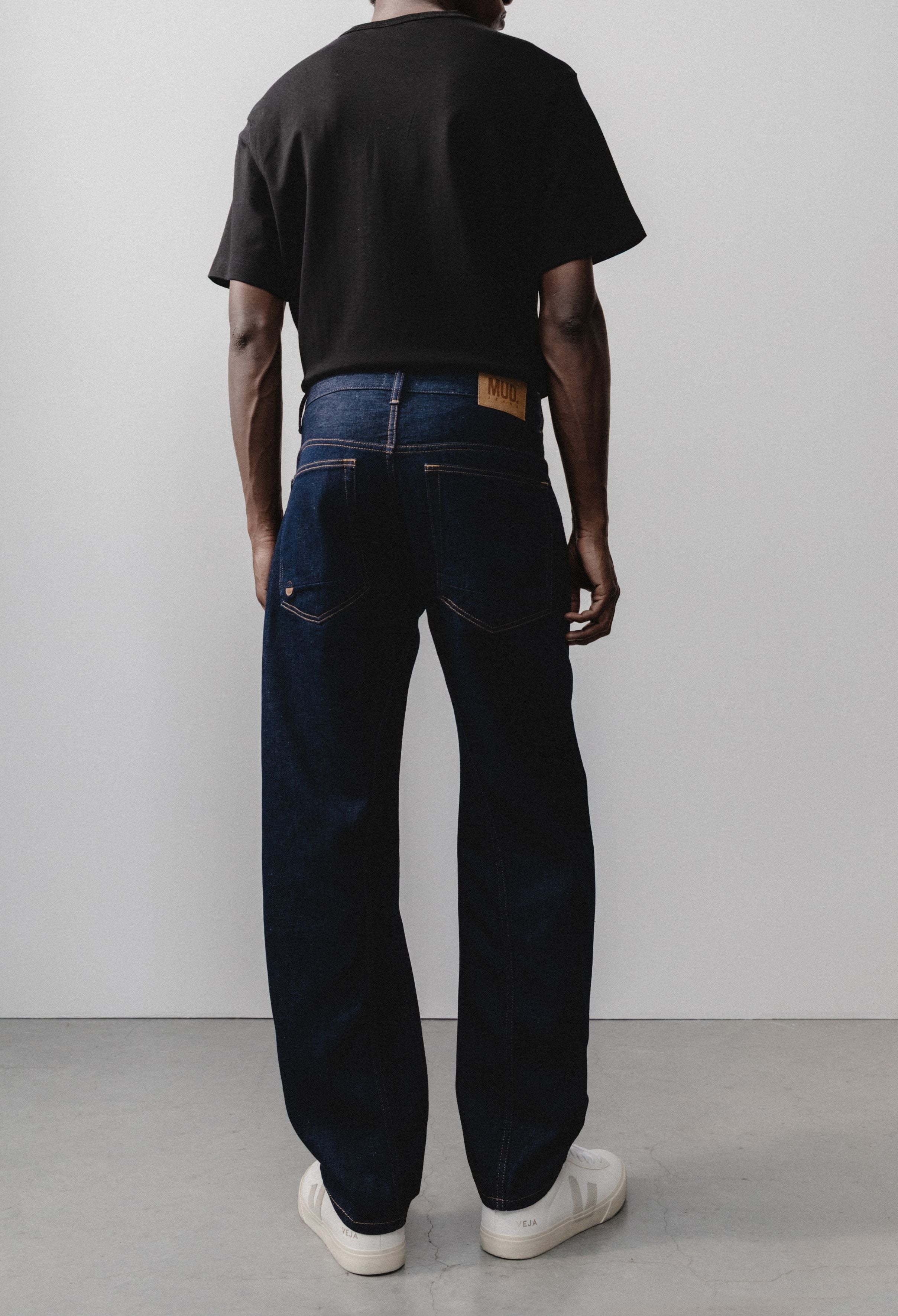 Sustainable MUD Jeans crafted from light blue organic cotton denim, paired with a plain white t-shirt for an ethical style.