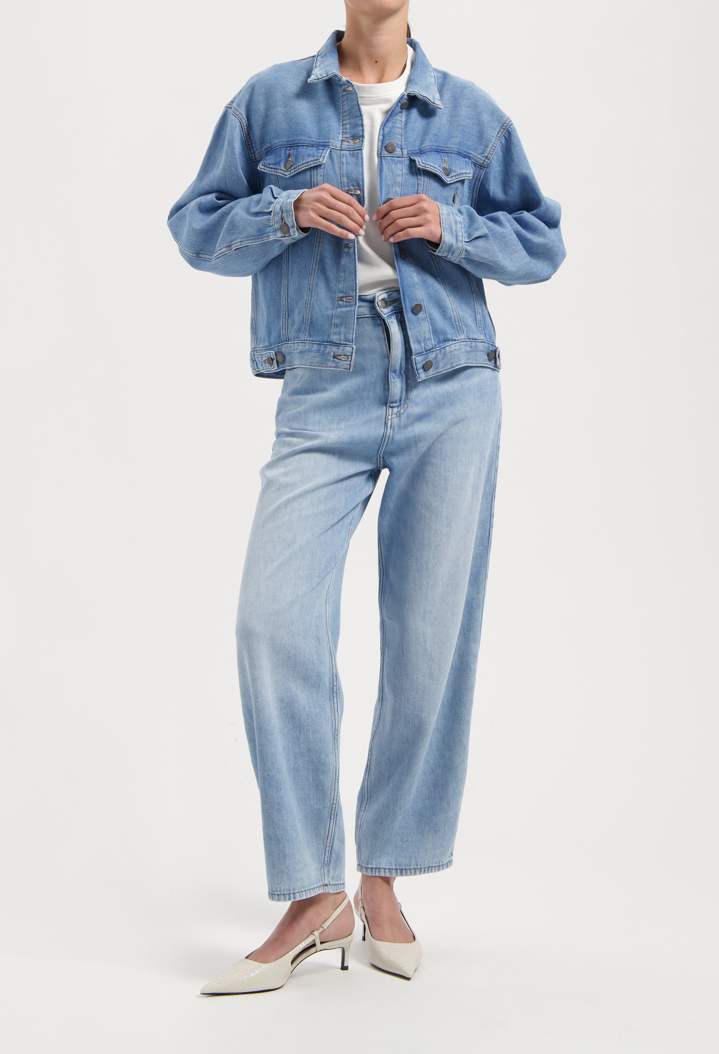 Light blue denim jacket and jeans set with relaxed fit, paired with a white tee and stylish cream slingback heels.