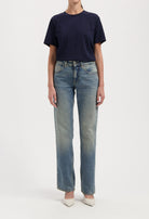 Casual outfit with a navy blue T-shirt paired with light-washed straight-leg jeans and white pointed-toe heels.