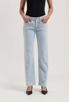 Light blue, high-waisted jeans in a classic fit, paired with a black sleeveless top and pointed black heels.