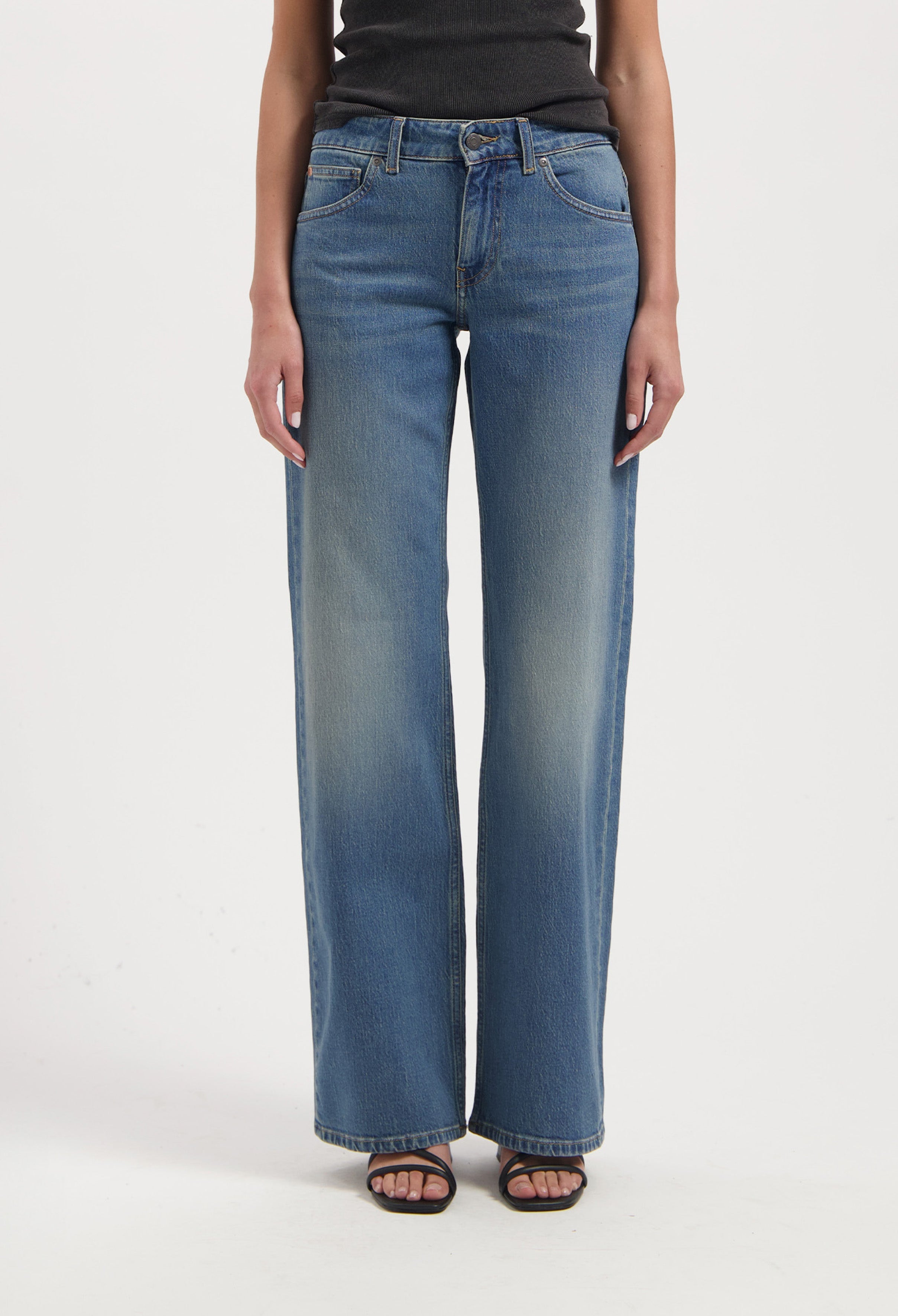 Wide-leg blue jeans with a faded wash, high waist, and classic five-pocket design, paired with a black sleeveless top.