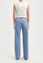 Back view of light blue, wide-leg jeans paired with a sleeveless white top, showcasing casual fit and sustainable material.