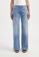 Wide-leg denim jeans in light blue, showcasing a casual fit, paired with a white tank top, creating a stylish casual look.