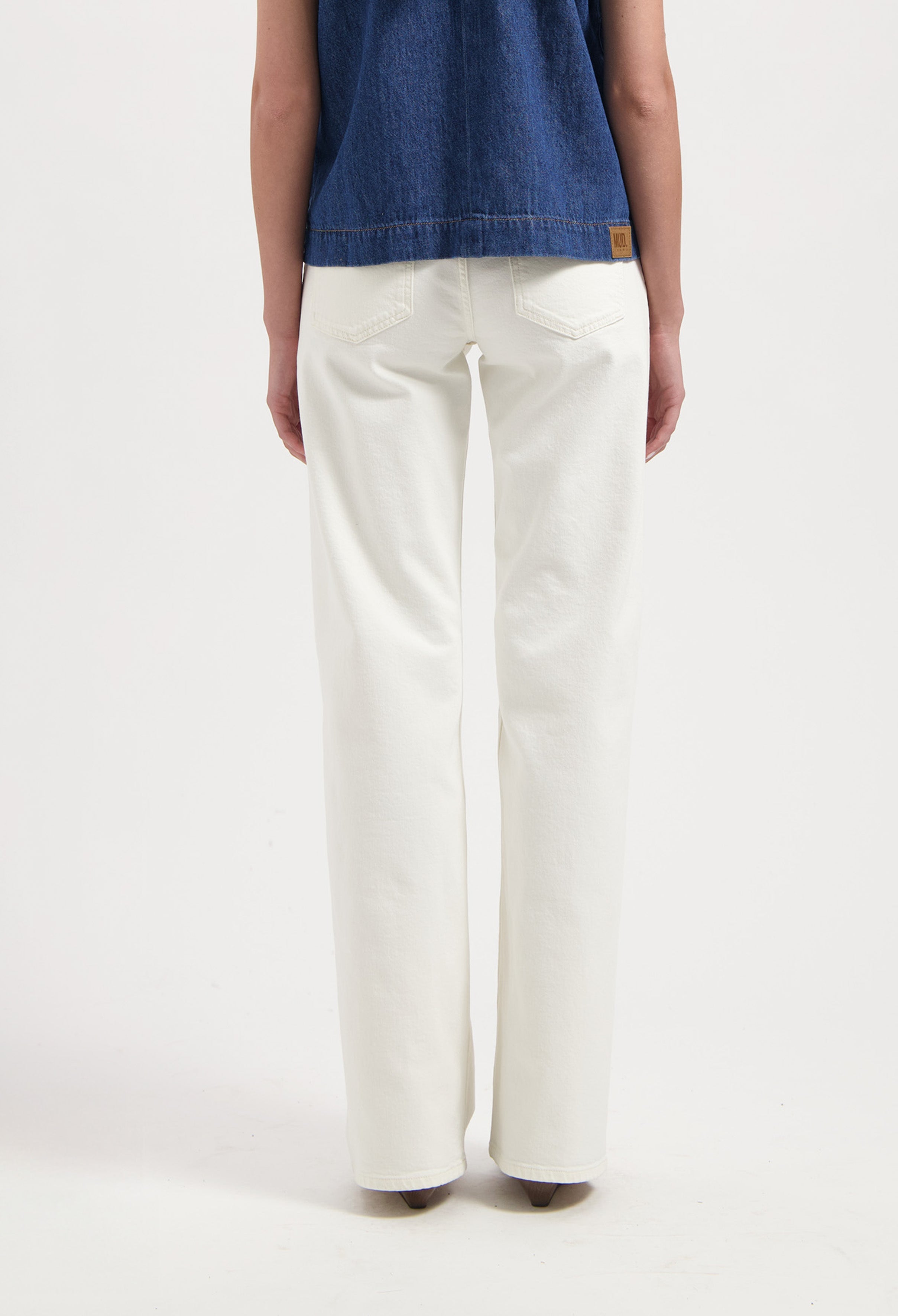 White straight-leg jeans made from organic cotton, shown from the back, paired with a dark blue sleeveless denim top.