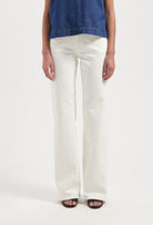 Wide-leg white jeans styled with an indigo denim sleeveless top, showcasing a minimalistic and modern fashion ensemble.
