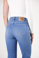 Slim-fit MUD Jeans in a light blue denim, showcasing the back details with pockets and eco-friendly leather patch.