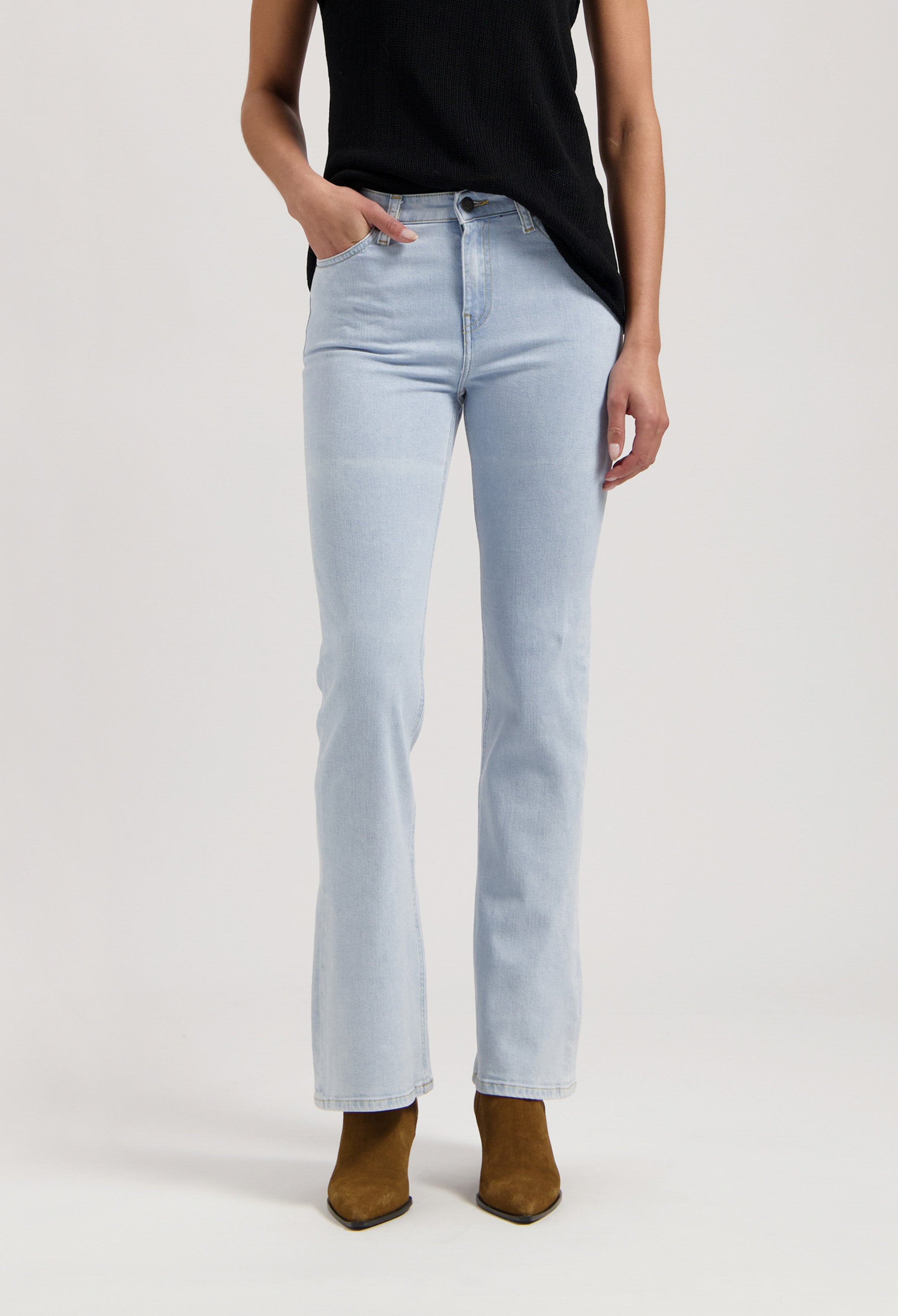 Light blue bootcut jeans with a high waist, paired with a sleeveless black top and brown ankle boots.