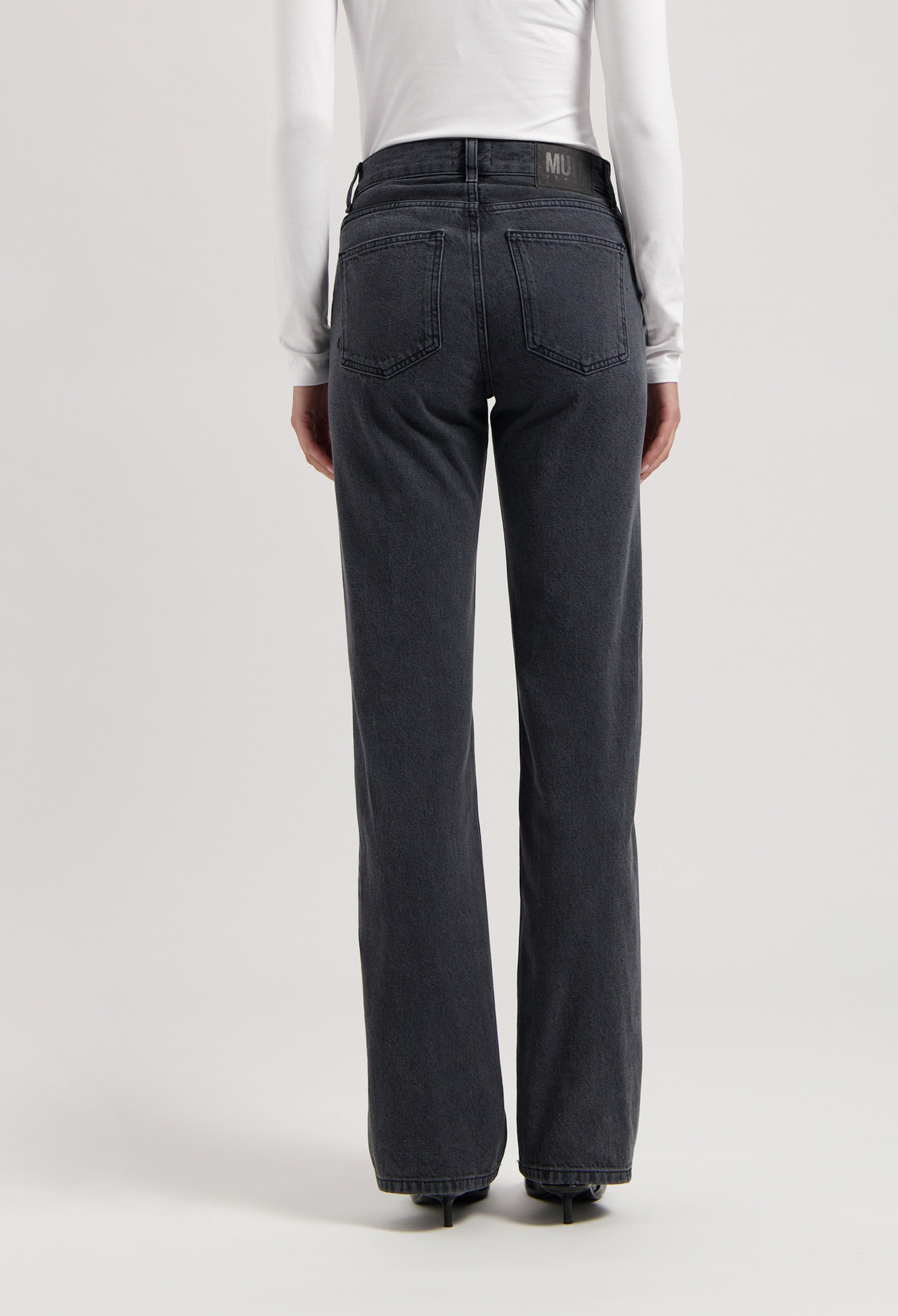 High-waisted, dark gray straight-leg jeans from MUD Jeans, featuring a subtle back pocket design, paired with a white long-sleeve top.