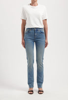 Casual outfit featuring a plain white short-sleeve top and high-waisted light blue jeans with front pockets, styled with black sandals.