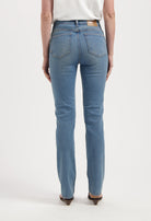 High-waisted light blue denim jeans with straight-leg fit, showcasing back pockets and worn with a tucked-in white tee.
