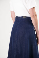 High-waisted dark blue MUD Jeans skirt made from organic cotton, paired with a classic white short-sleeve top.