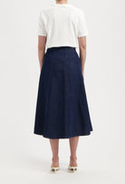 A-line dark blue denim skirt paired with a white short-sleeve top, showcasing a casual, elegant look from the back.