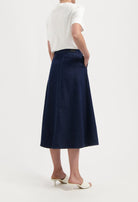 A-line dark blue denim skirt paired with a white top, showcasing stylish and simple summer fashion.