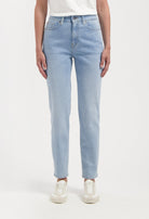 Light blue straight-leg jeans made from eco-friendly denim, worn with a minimalist white T-shirt and beige sneakers.