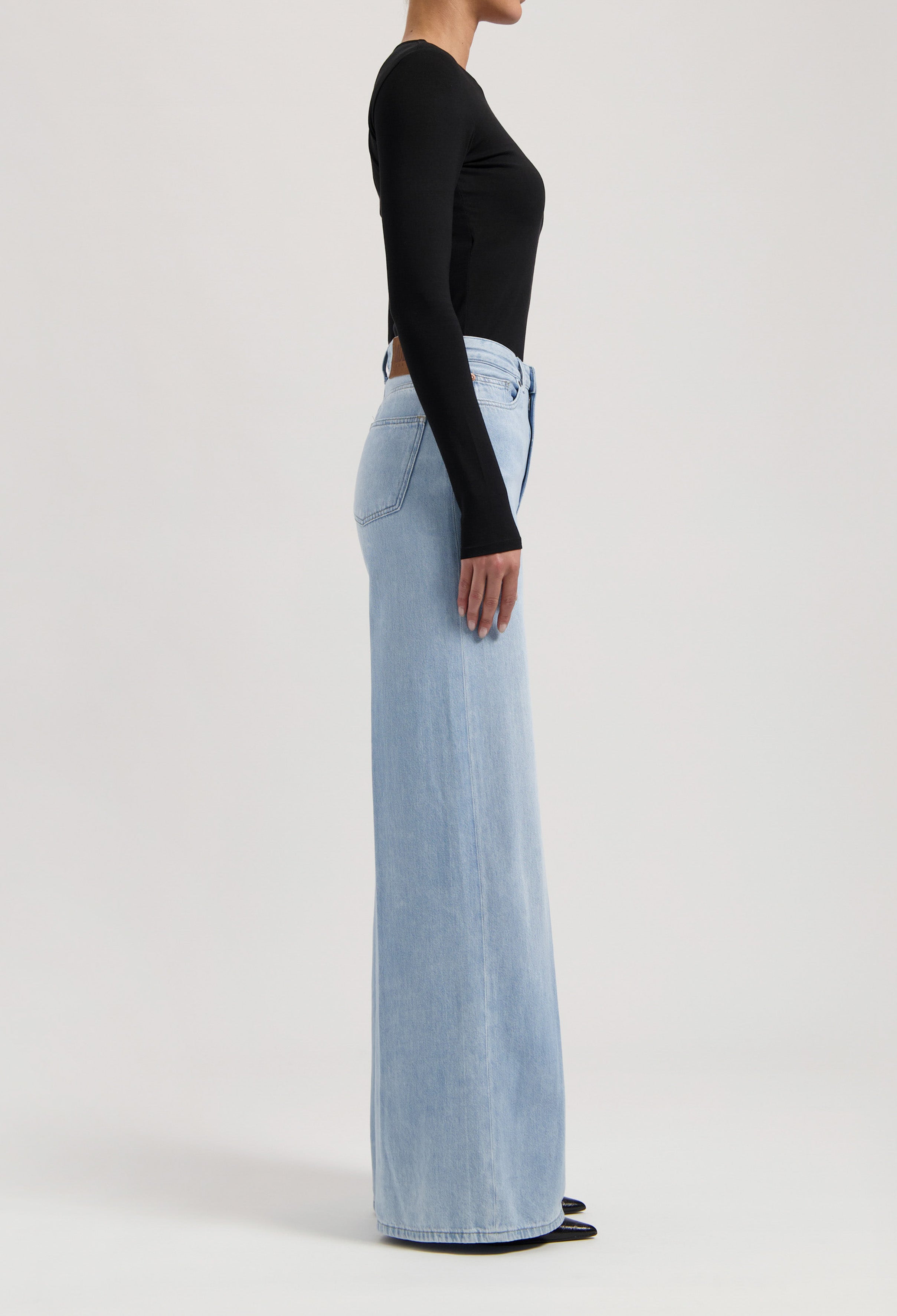 Light blue wide-leg denim jeans paired with a fitted black long-sleeve top, highlighting modern casual streetwear style.