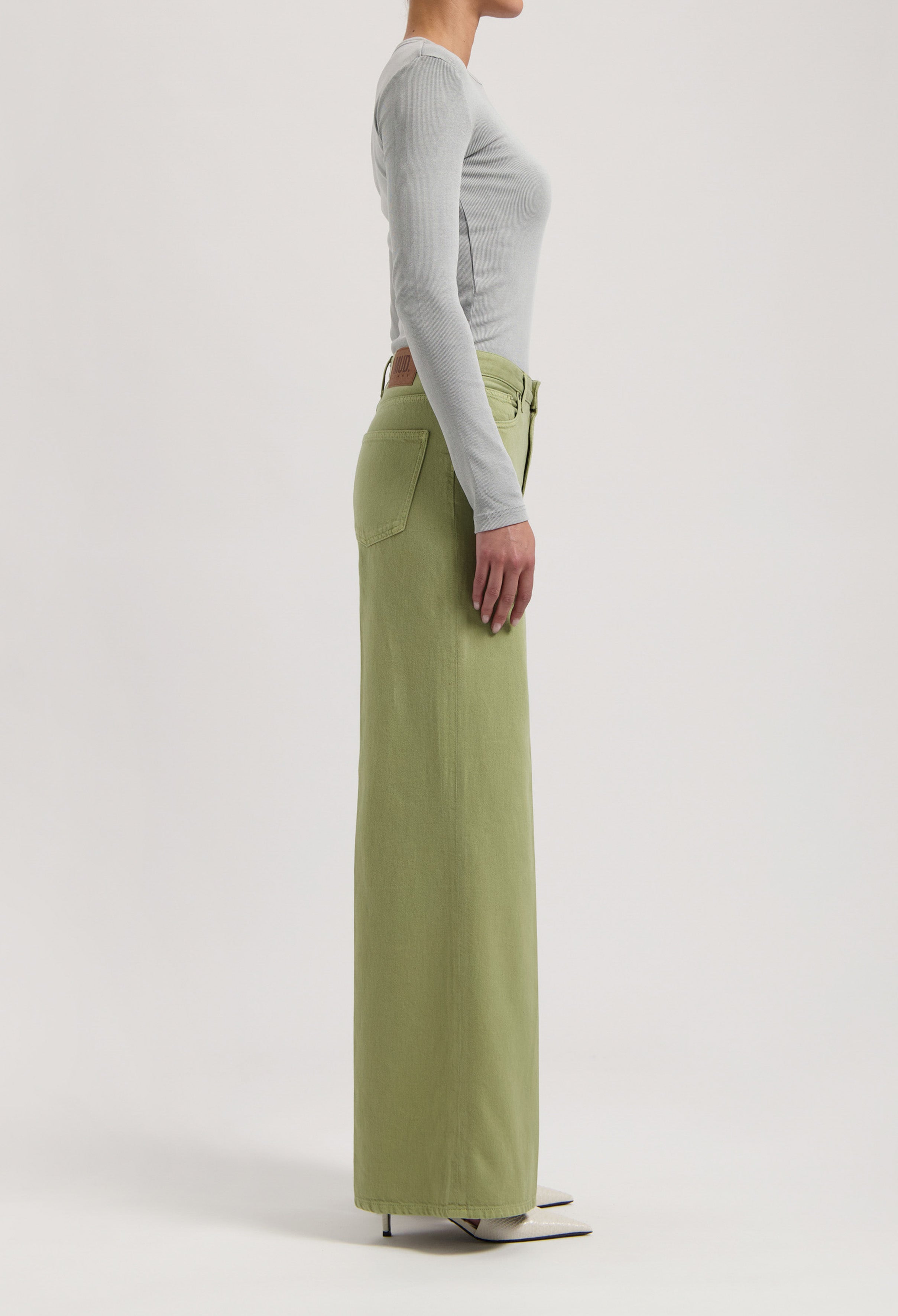 Olive green high-waisted wide-leg pants displayed in profile, paired with a light gray fitted long-sleeve top.