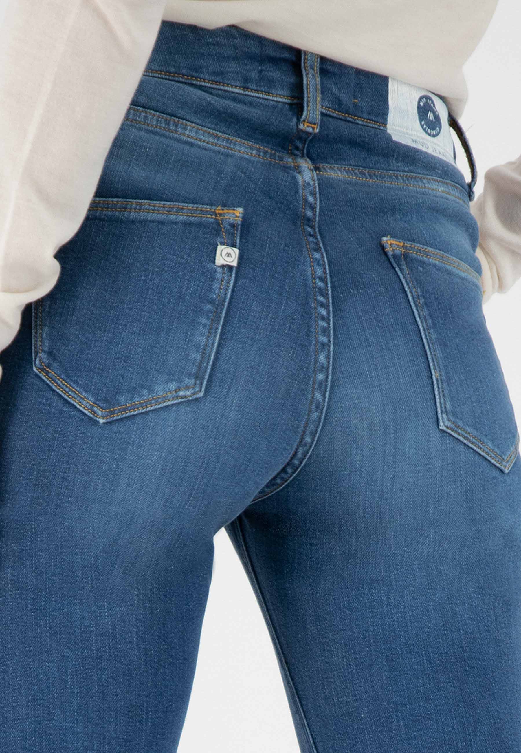 Close-up of classic blue denim jeans with visible back pockets, highlighting detailed stitching and a slim, flattering fit.